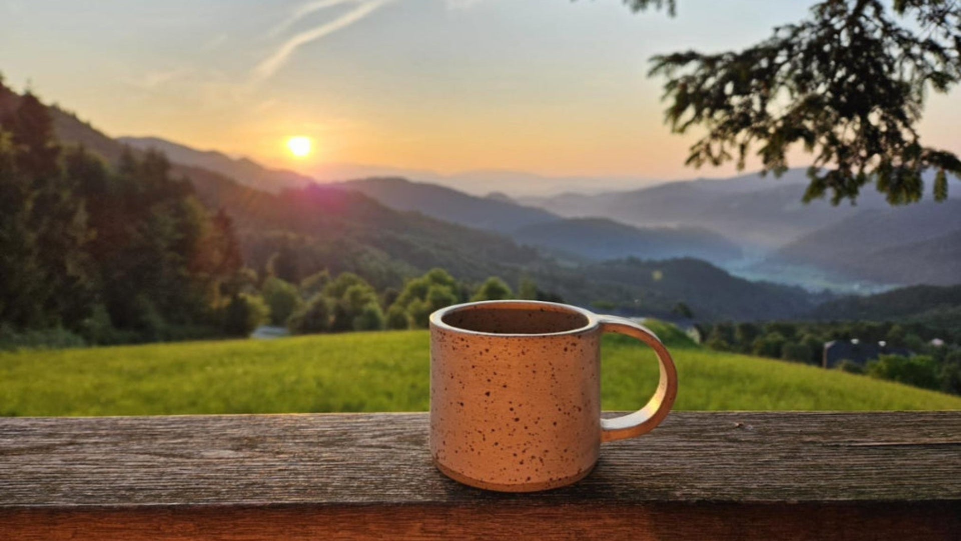 Handgemaakte whitewashed keramieken mok op balkon bij zonsopkomst, bergen op de achtergrond, perfect voor je ochtendkoffie