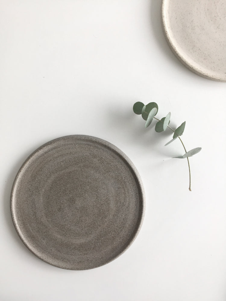 Donker en licht handgemaakt cakebord van keramiek naast elkaar