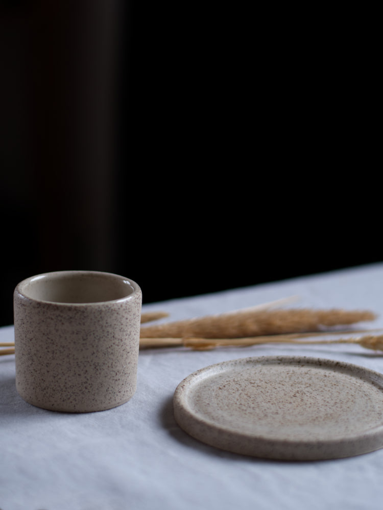 Handgemaakt espressokopje van keramiek naast een bijpassende schotel