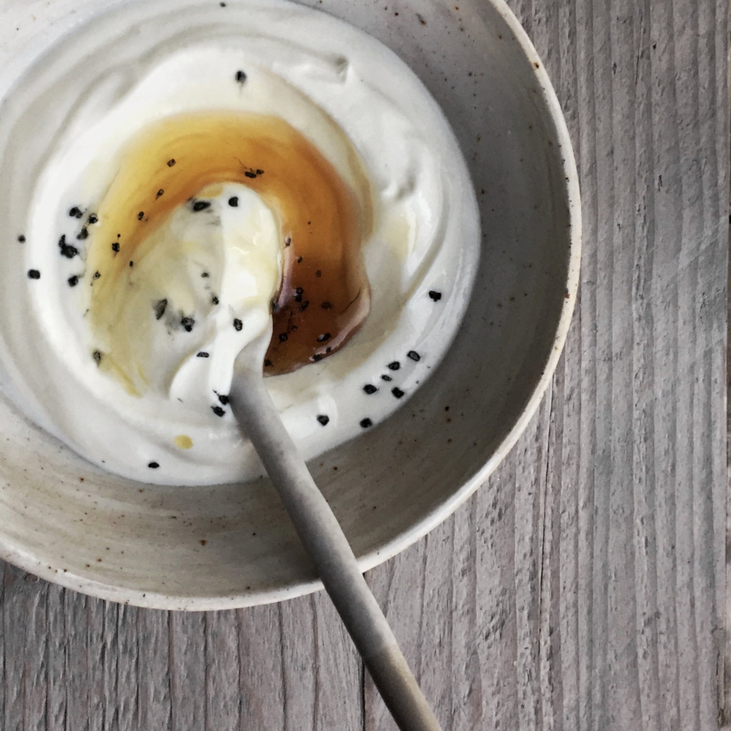 Yoghurt met honing en lavazout in een handgemaakte kom en keramieken lepel