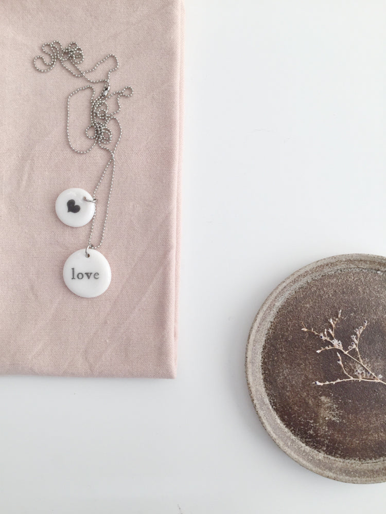 Handgemaakte keramieken ketting met medium hanger Love en kleine hanger met zwart hartje