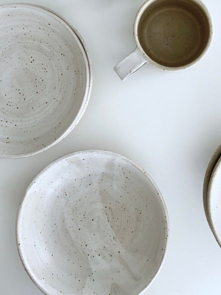 Handgemaakte whitewashed keramieken kom met witte vlek en mok en andere whitewashed kommen