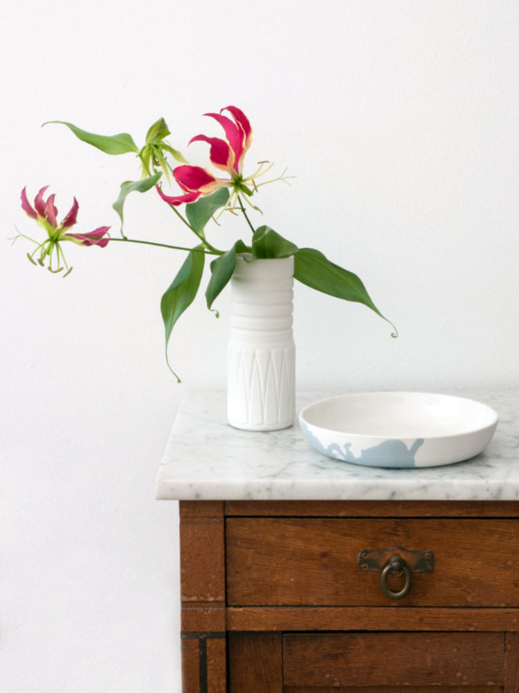 Antiek kastje met daarop een handgemaakte porseleinen vaas en een porseleinen lage kom