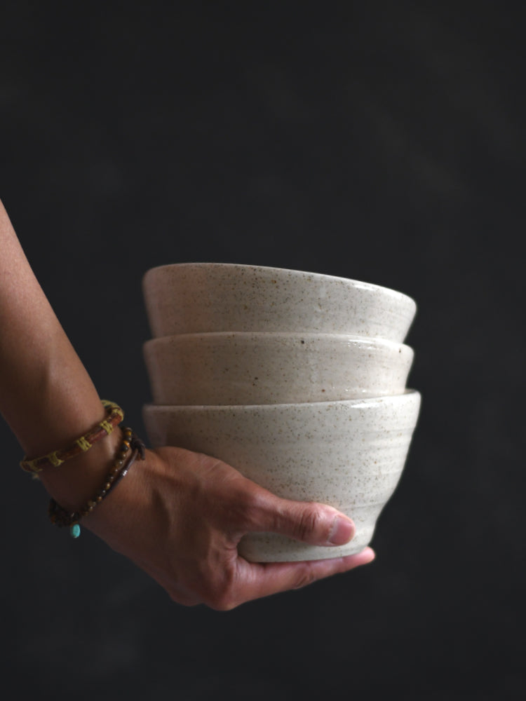 Kommen handgemaakt gestapeld vastgehouden door een hand donkere achtergrond