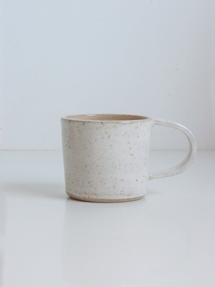 Handgemaakte witgespikkelde mok met glanzend glazuur