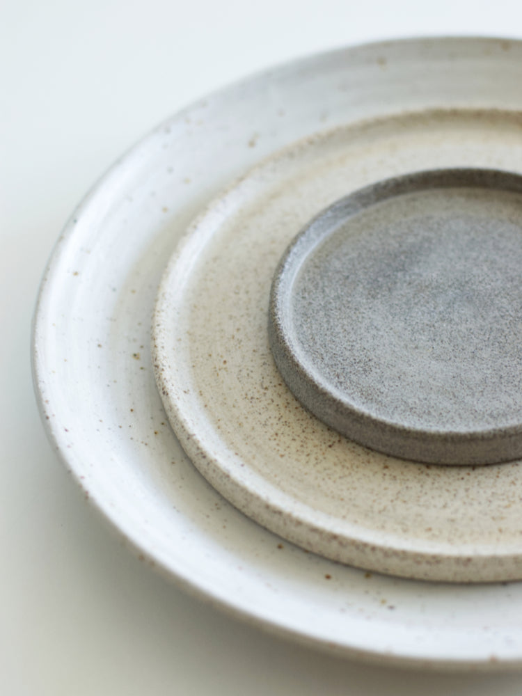 Set handgemaakte keramieken borden, gestapeld op elkaar in verschillende kleuren