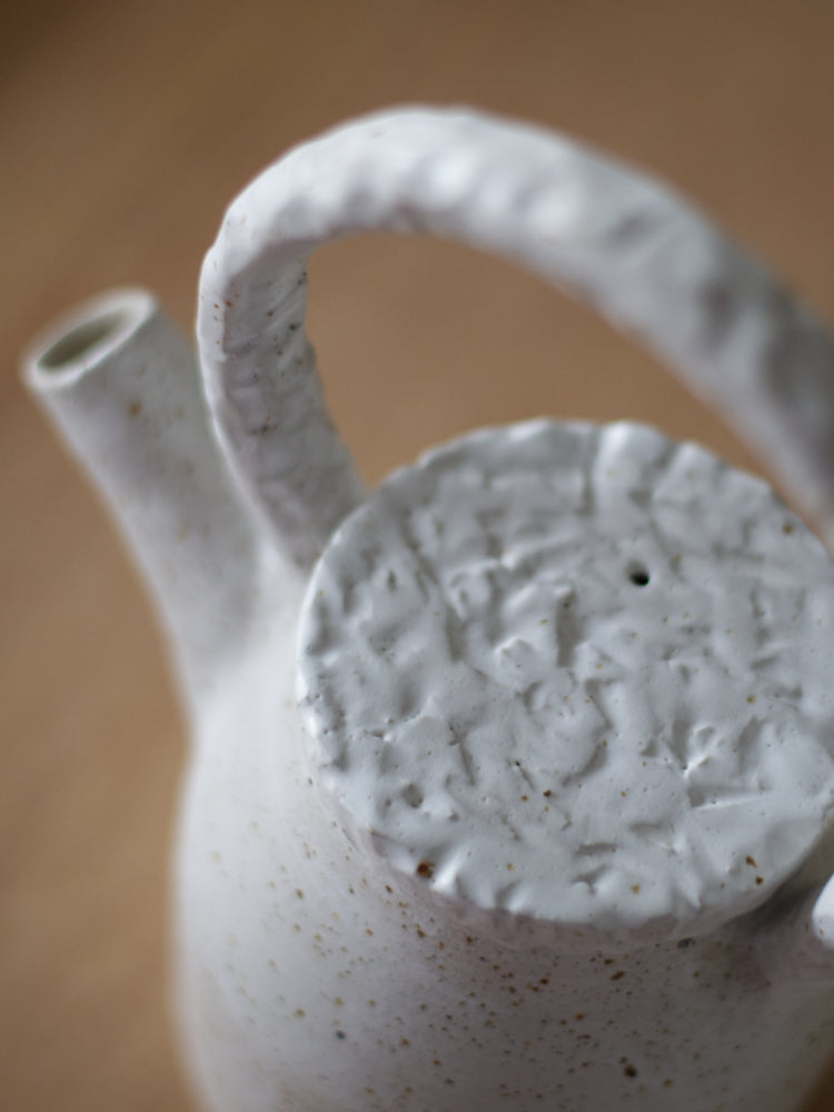 Handgemaakte theepot met whitewashed en reliëf deksel en handvat closeup