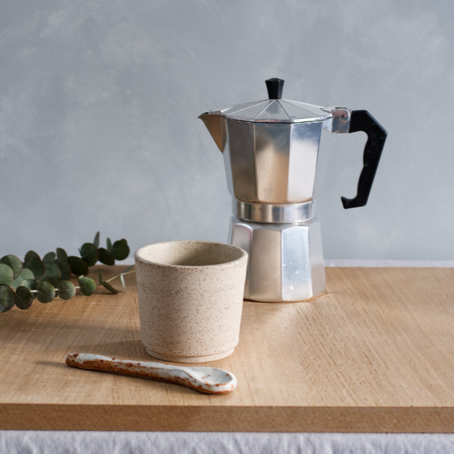 Handgemaakt keramieken kopje met percolator op houten plank, ambachtelijk keramiek voor koffie- of theemomenten