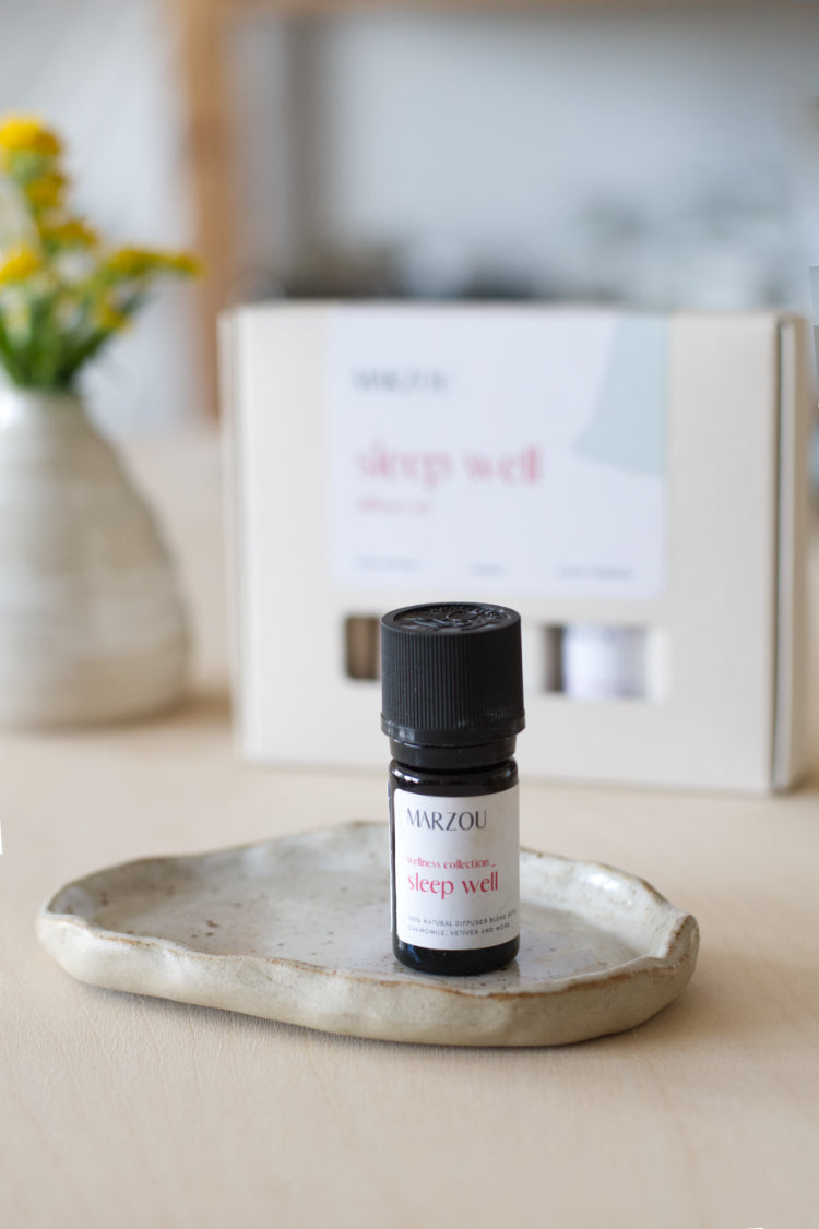 Handgemaakt keramisch schaaltje met geurolie naast een kleine keramieken vaas