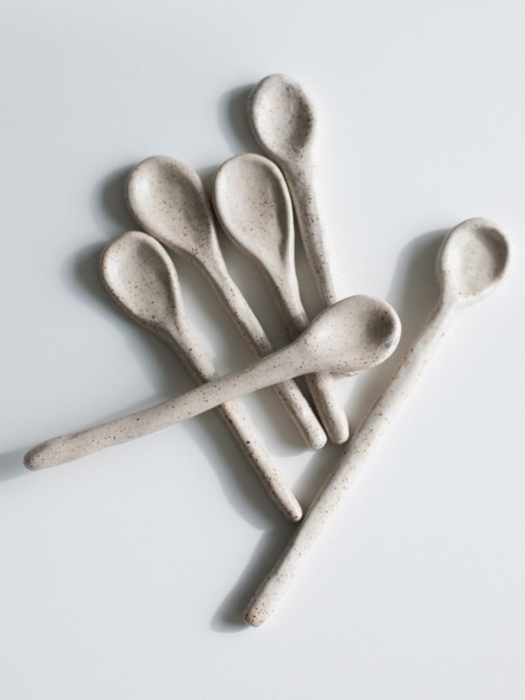 Handgemaakte keramieken lepels gestapeld op witte achtergrond