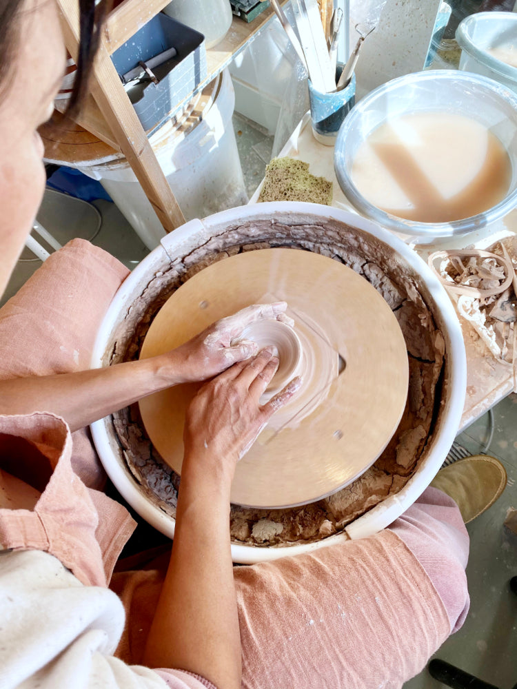 Vrouw draaiend achter de draaischijf