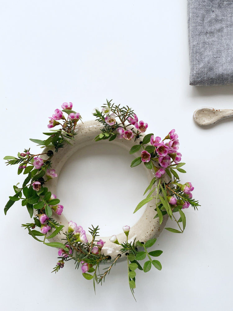 Ronde bloemenvaas met roze bloemen bovenaanzicht op witte achtergrond